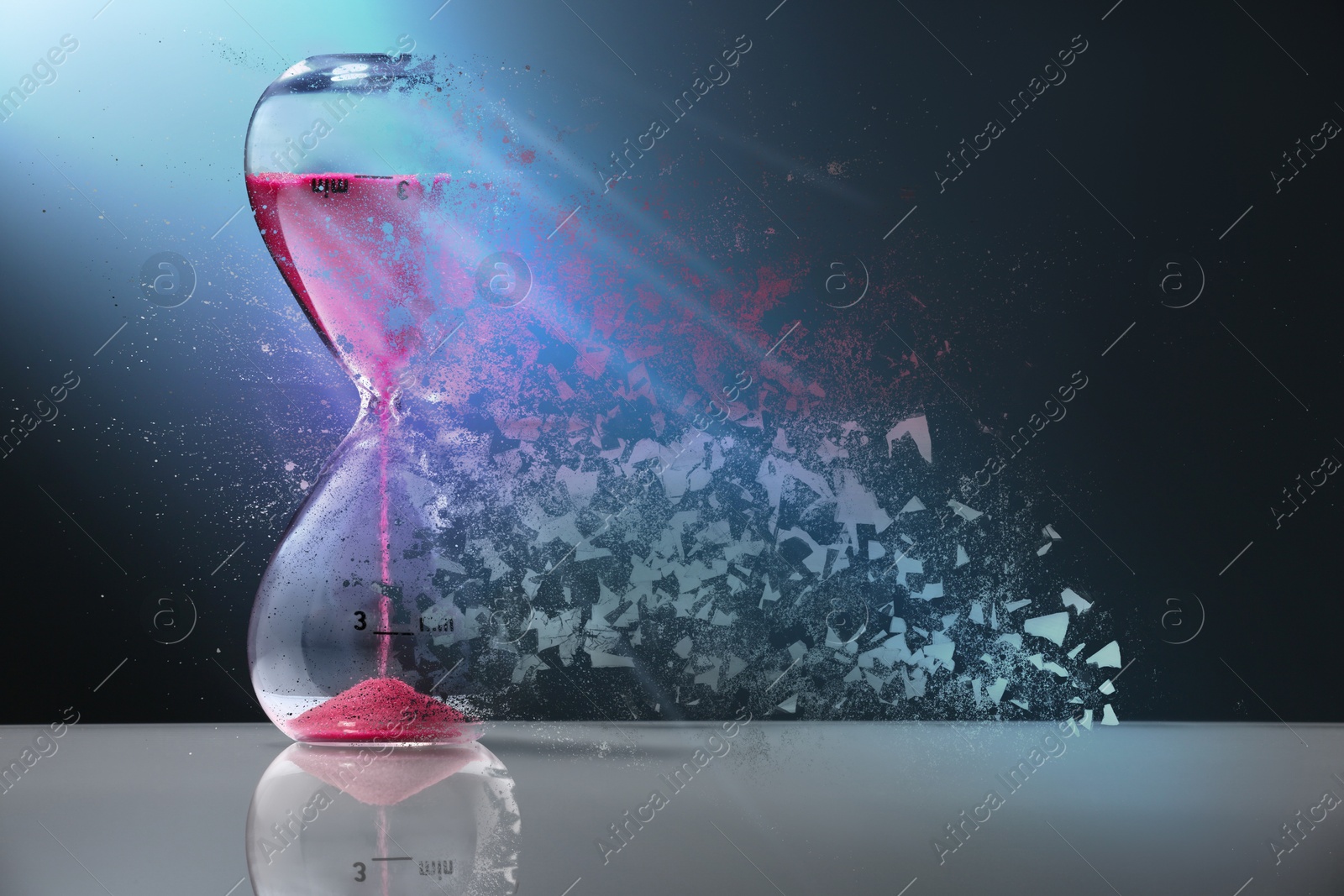 Image of Hourglass dissolving on table against dark background. Fleeting time