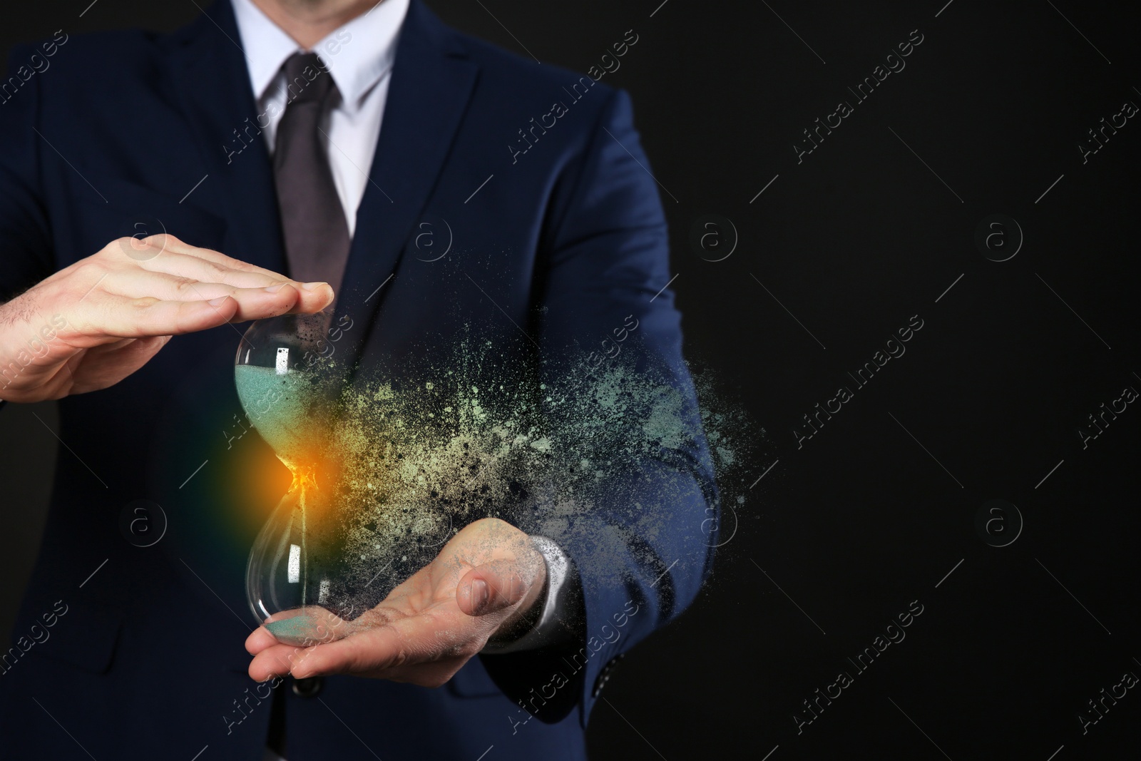 Image of Businessman holding dissolving hourglass on black background, closeup. Time is running out