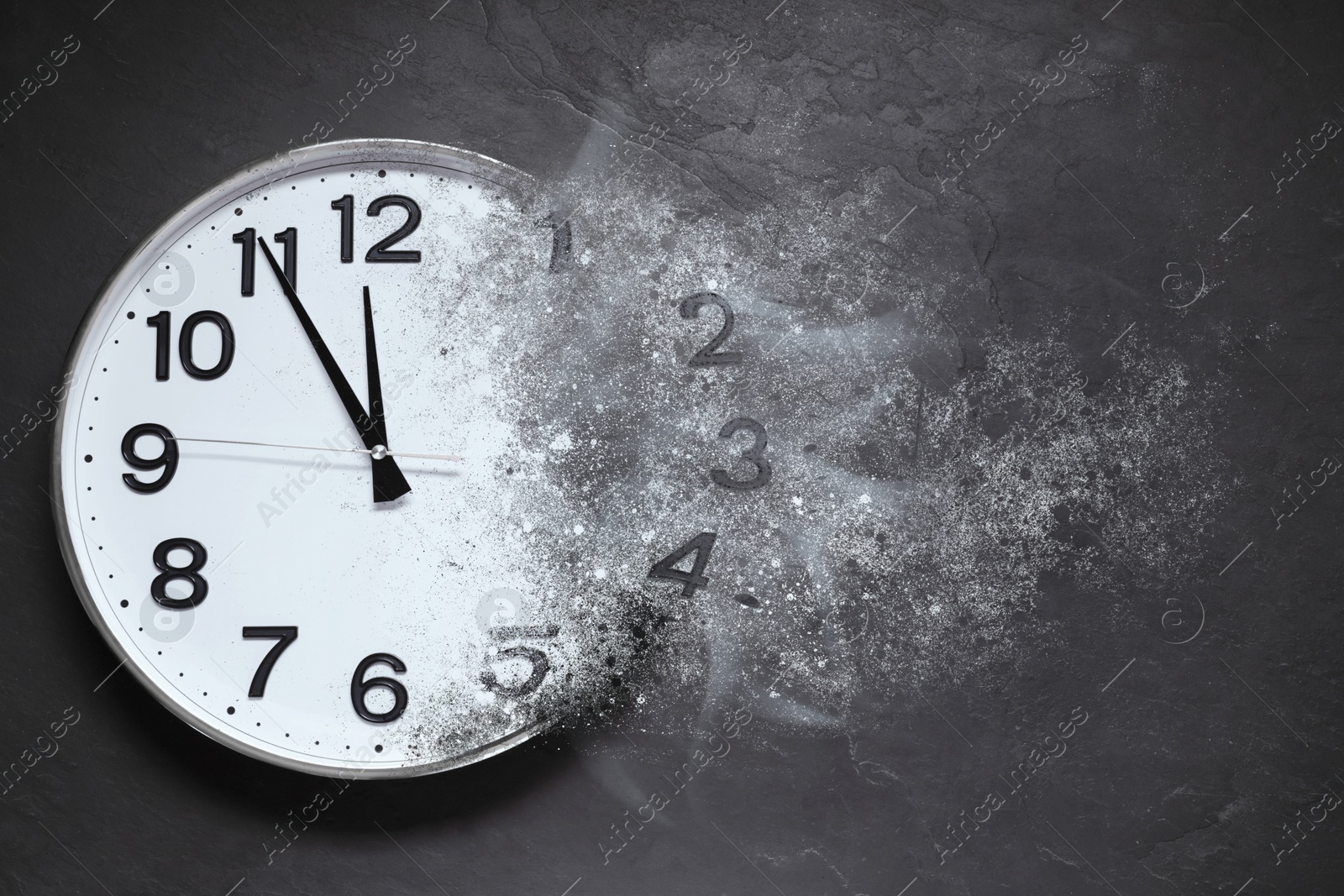 Image of Analog clock dissolving on dark background. Fleeting time
