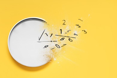 Analog clock dissolving on yellow background. Time is running out