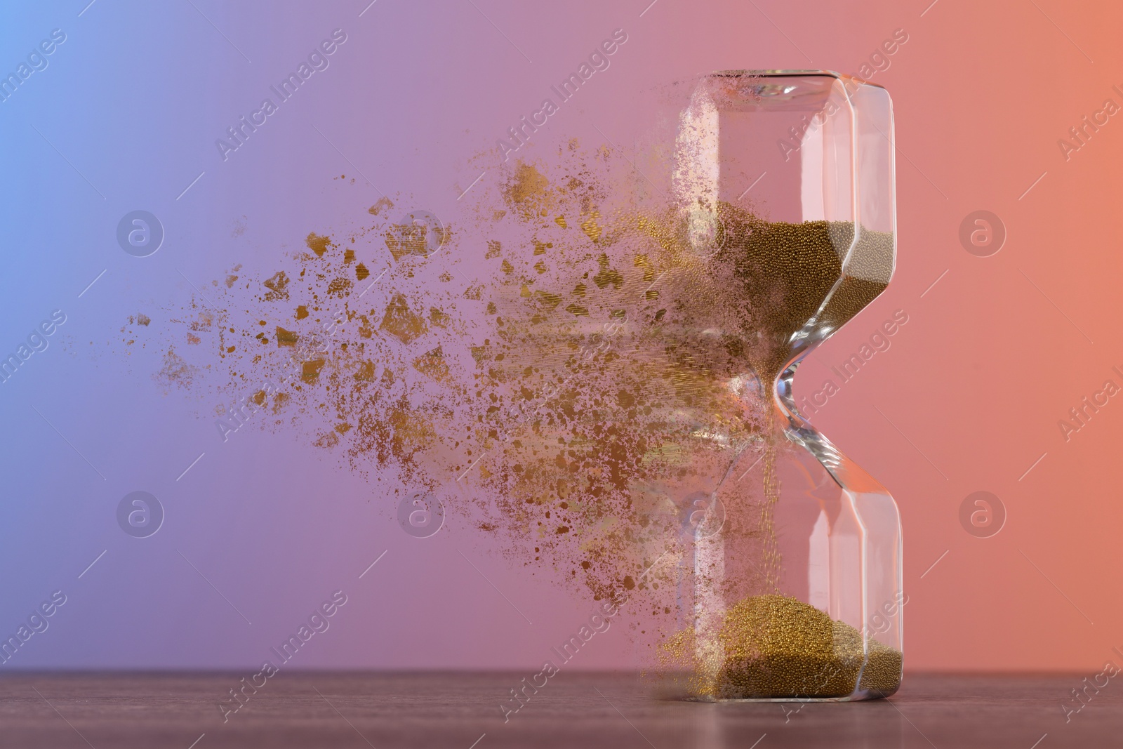 Image of Hourglass dissolving on table against color background. Fleeting time