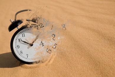 Image of Alarm clock dissolving among desert. Time is running out