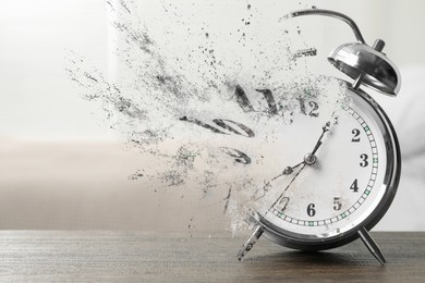 Image of Alarm clock dissolving on table indoors. Time is running out