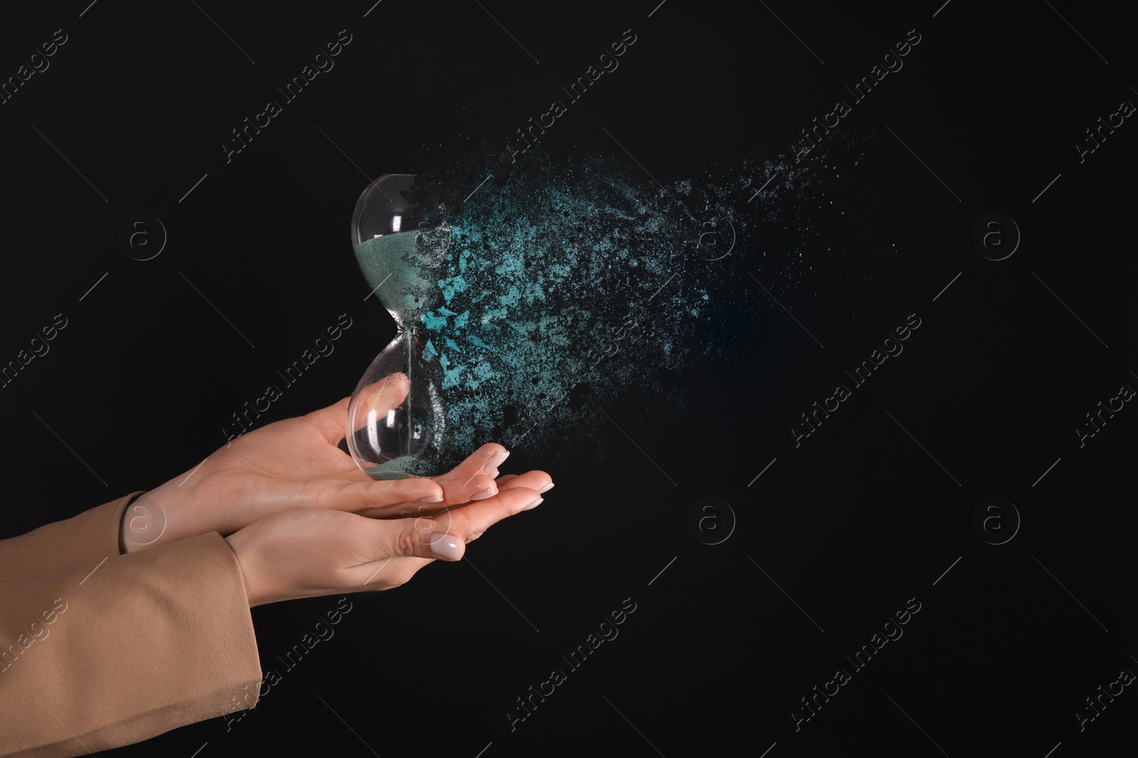 Image of Businesswoman holding dissolving hourglass on black background, closeup. Time is running out