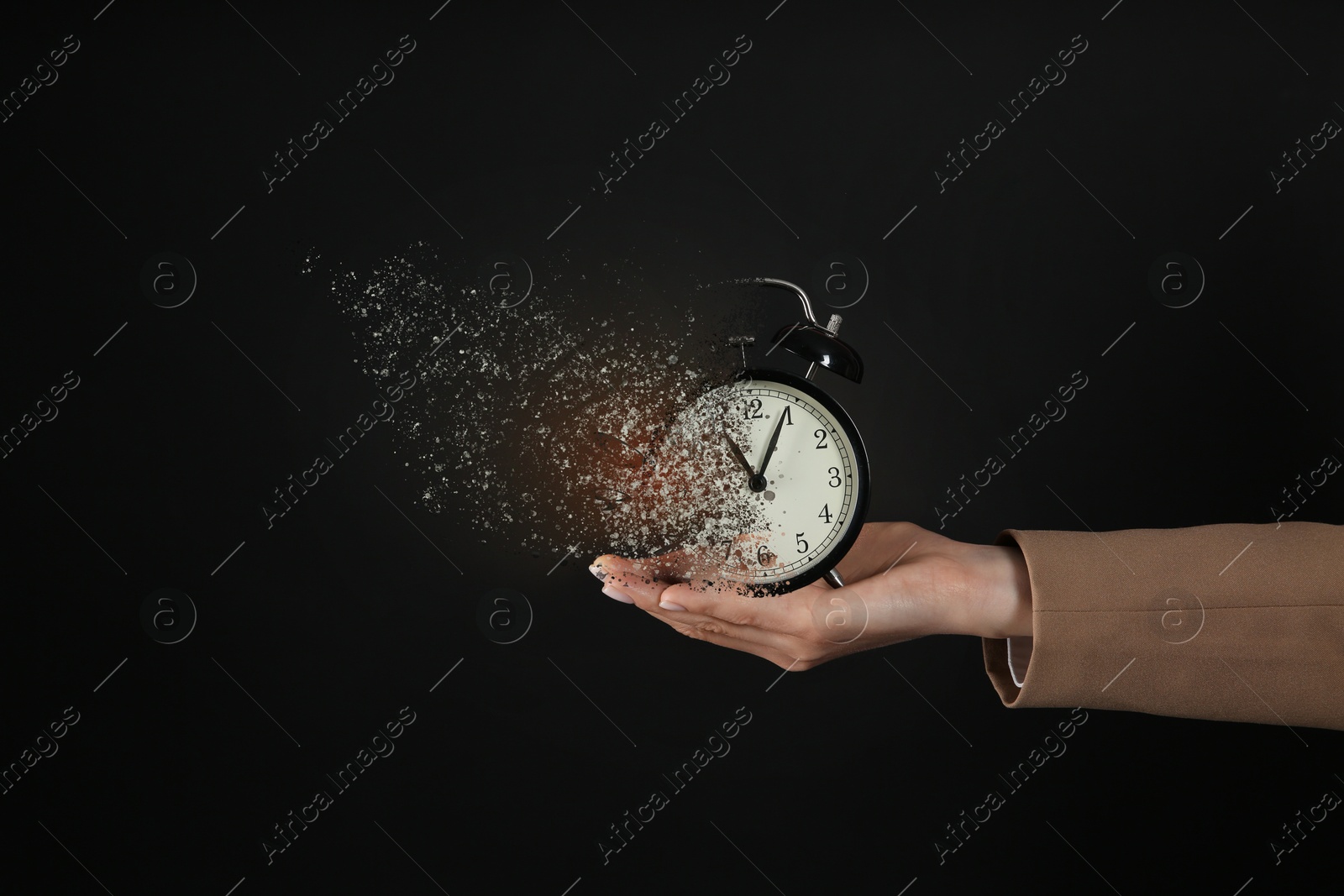 Image of Businesswoman holding dissolving alarm clock on black background, closeup. Time is running out