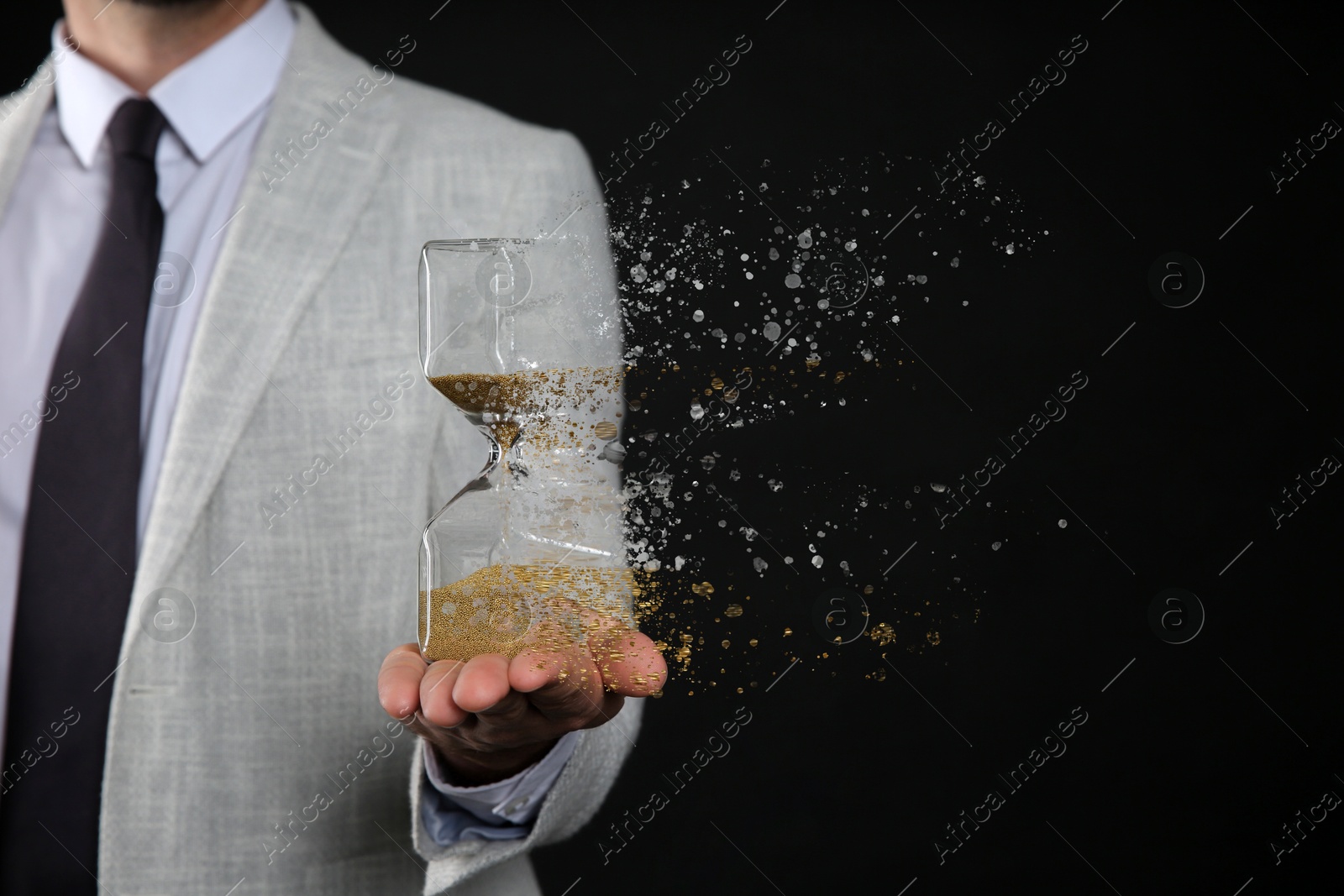 Image of Businessman holding dissolving hourglass on black background, closeup. Time is running out