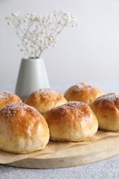 Photo of Delicious dough balls and flowers on grey table, closeup