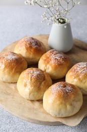 Delicious dough balls and flowers on grey table, closeup