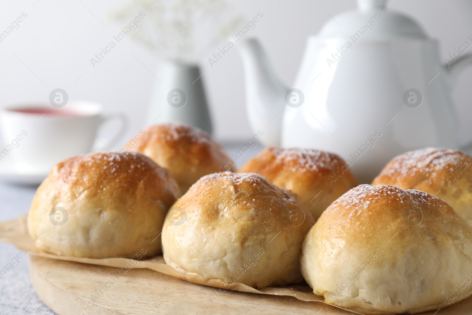 Photo of Delicious dough balls and tea on grey table, selective focus