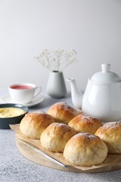 Photo of Delicious dough balls, sauce and tea on grey table, selective focus