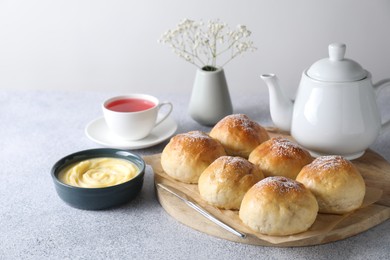 Photo of Delicious dough balls, sauce and tea on grey table