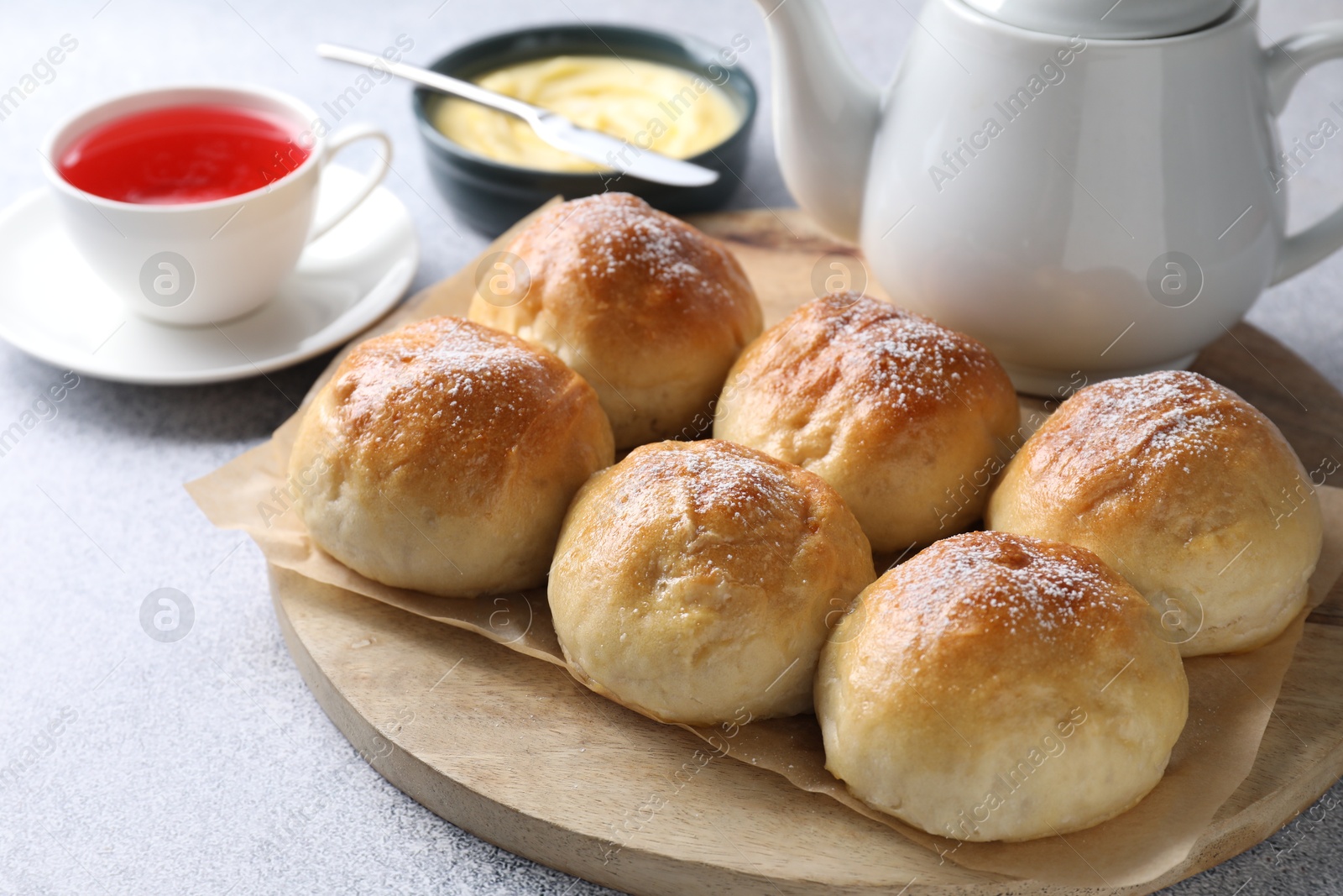 Photo of Delicious dough balls, sauce and tea on grey table, selective focus