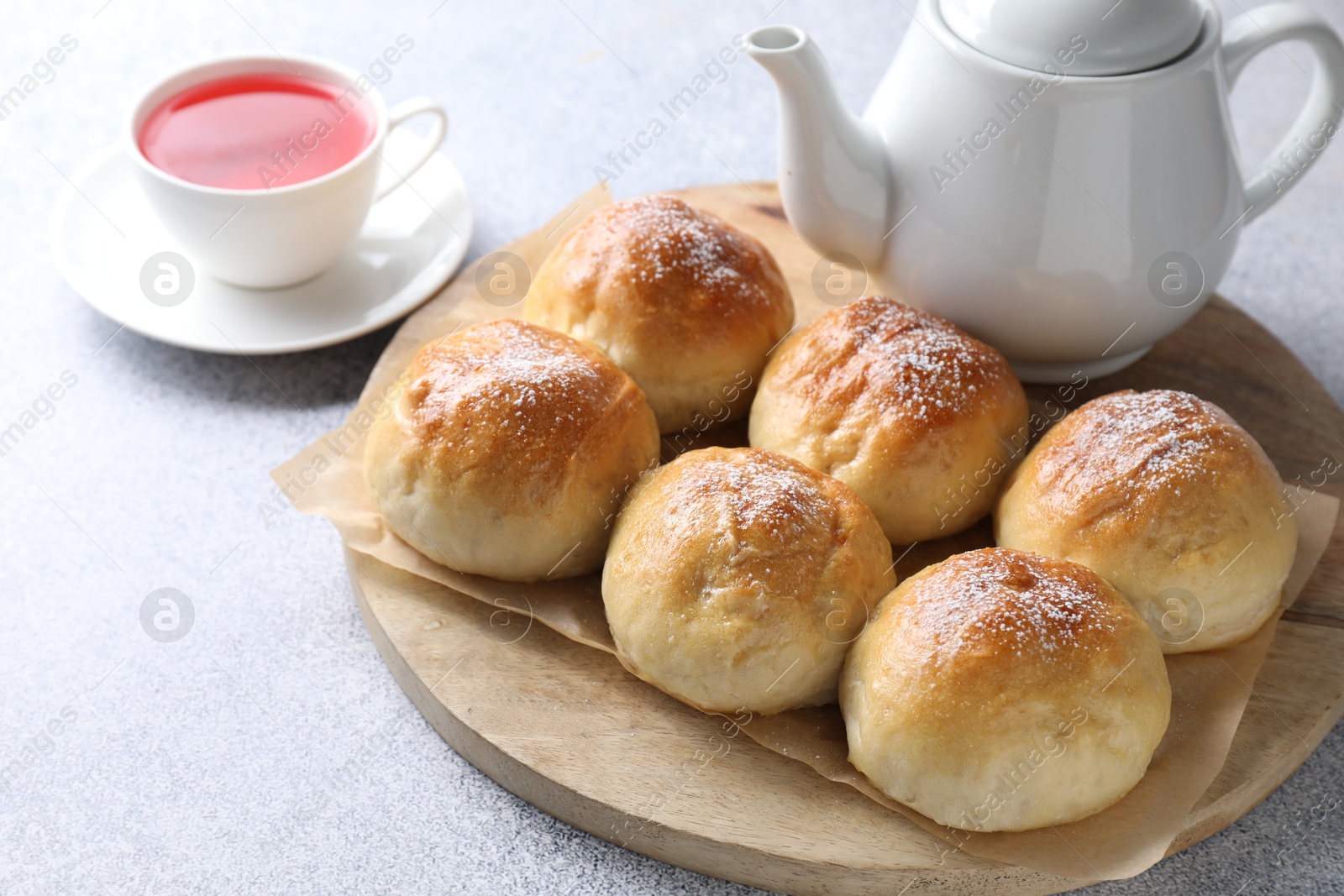 Photo of Delicious dough balls and tea on grey table, closeup