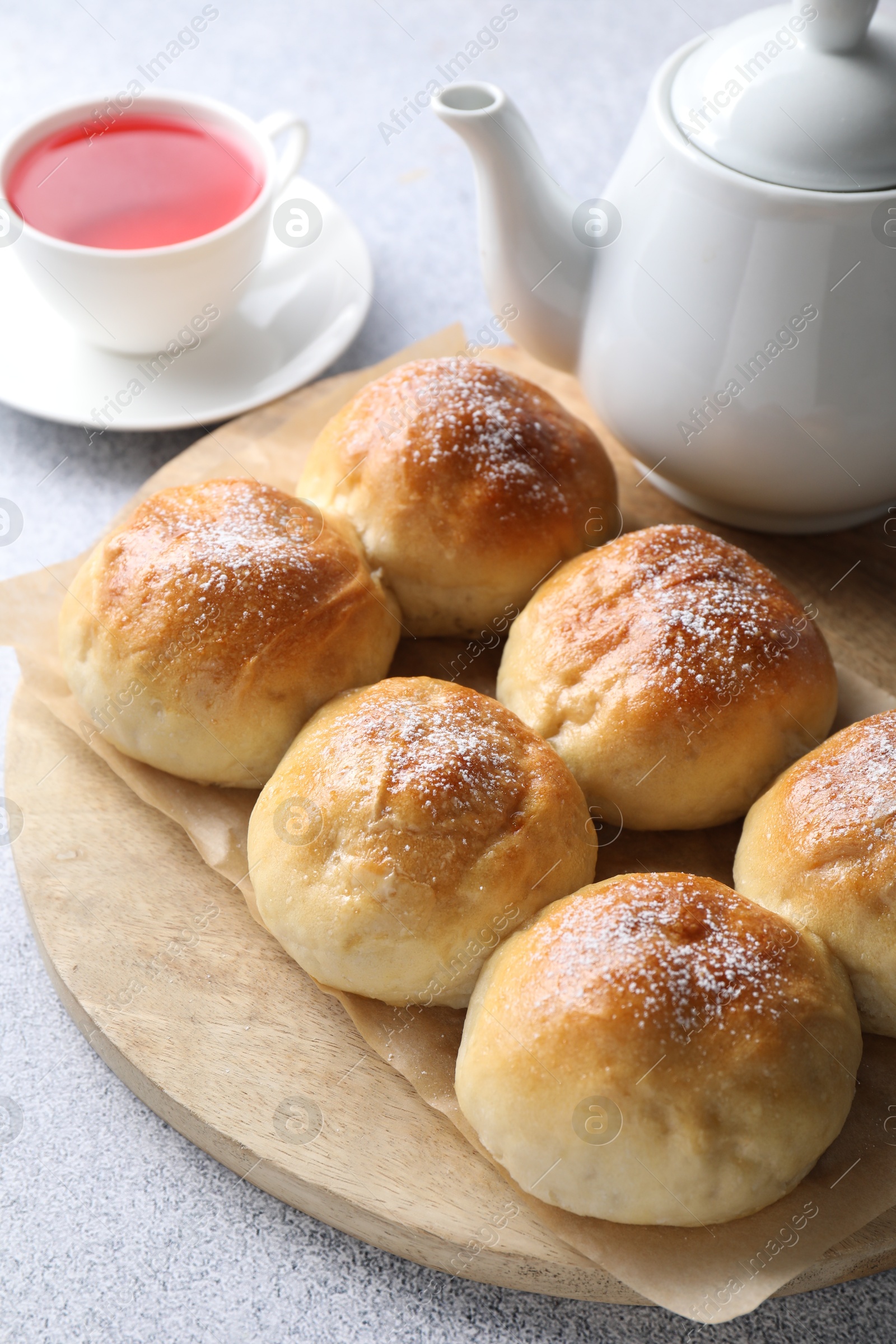 Photo of Delicious dough balls and tea on grey table, closeup