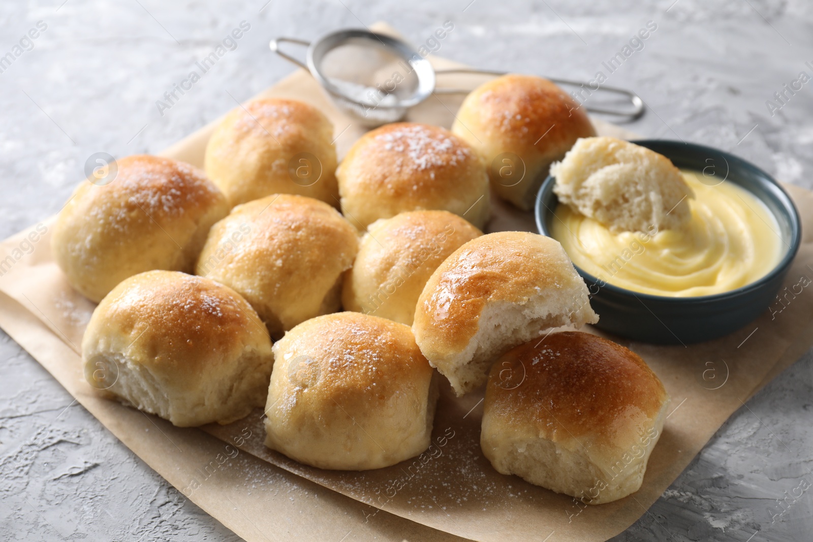 Photo of Delicious dough balls and sauce on grey table, closeup