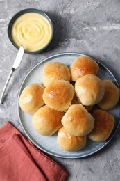 Delicious dough balls and sauce on grey table, top view