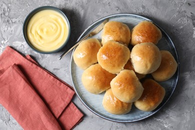 Delicious dough balls and sauce on grey table, top view