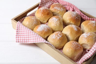 Photo of Delicious dough balls in crate on white table