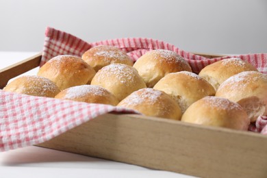 Photo of Delicious dough balls in crate on white table