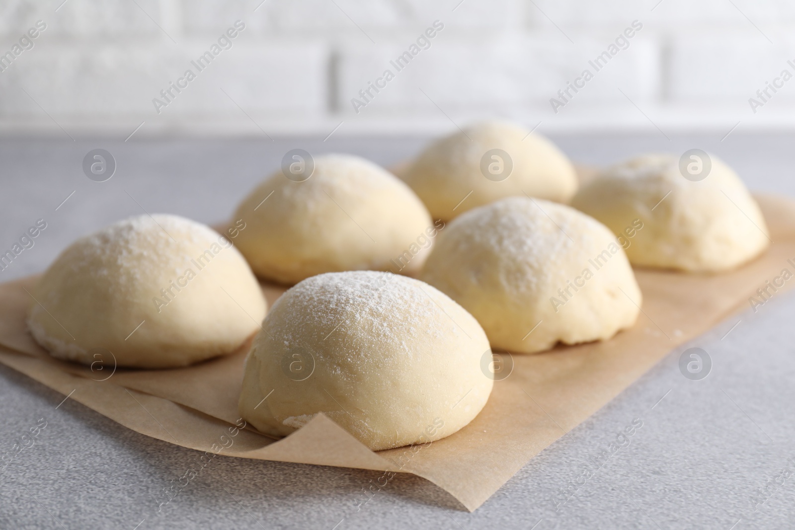 Photo of Raw dough balls on light grey table