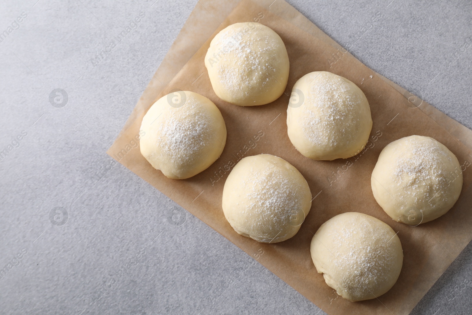 Photo of Raw dough balls on light grey table, top view. Space for text