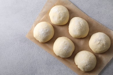 Raw dough balls on light grey table, top view. Space for text