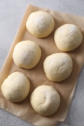 Photo of Raw dough balls on light grey table, top view