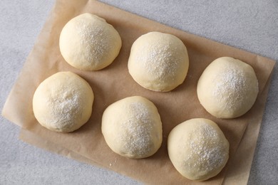 Raw dough balls on light grey table, top view