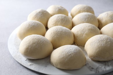 Raw dough balls on light grey table, closeup