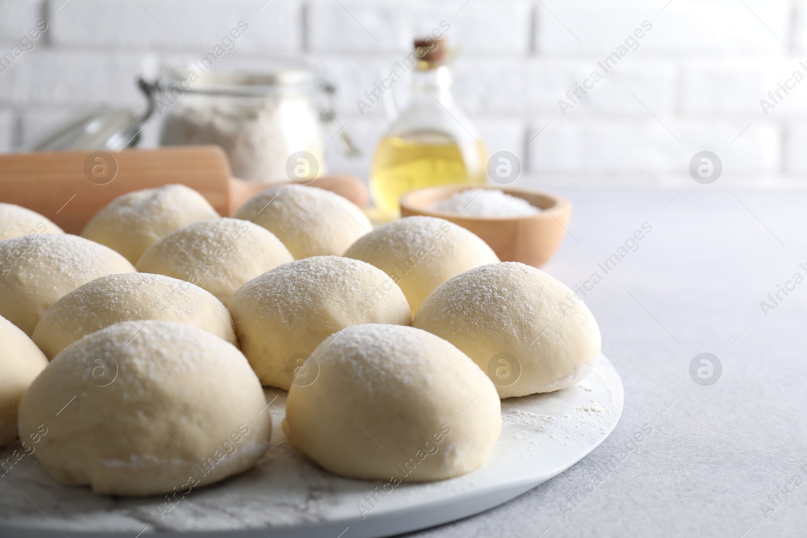 Photo of Raw dough balls on light grey table. Space for text