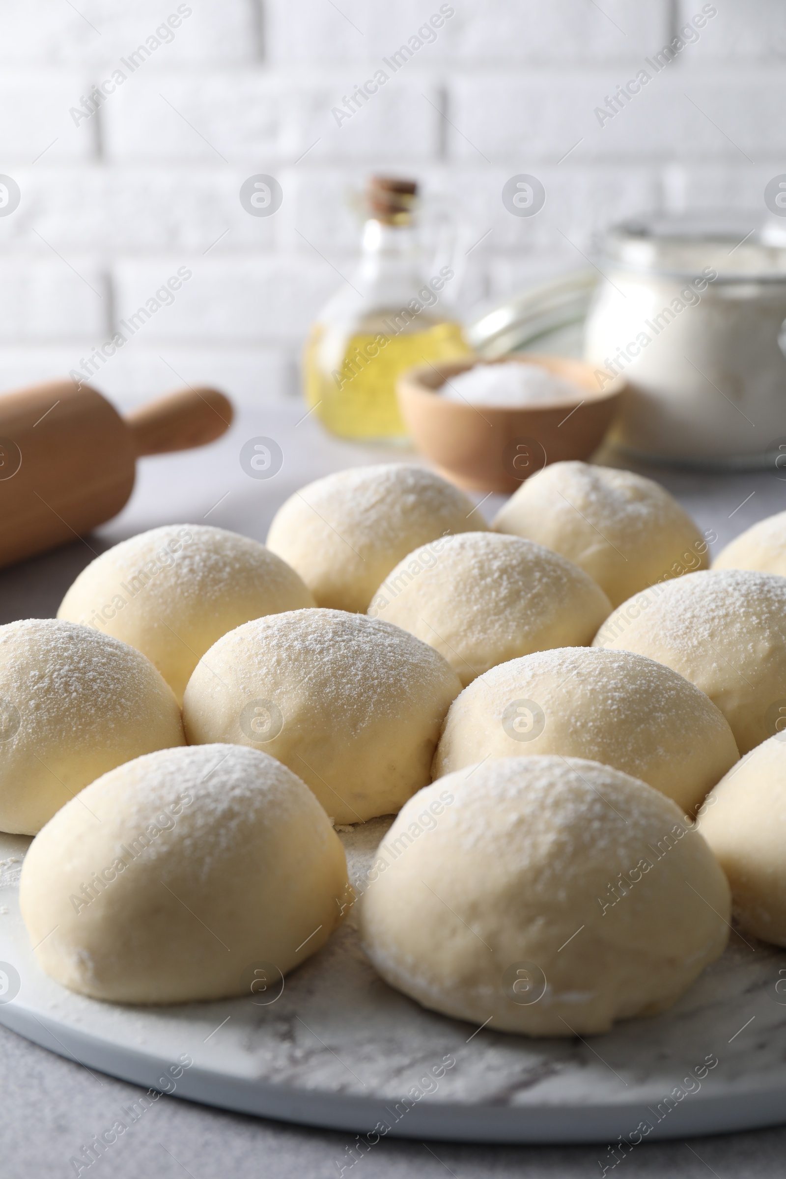 Photo of Raw dough balls on light grey table, closeup