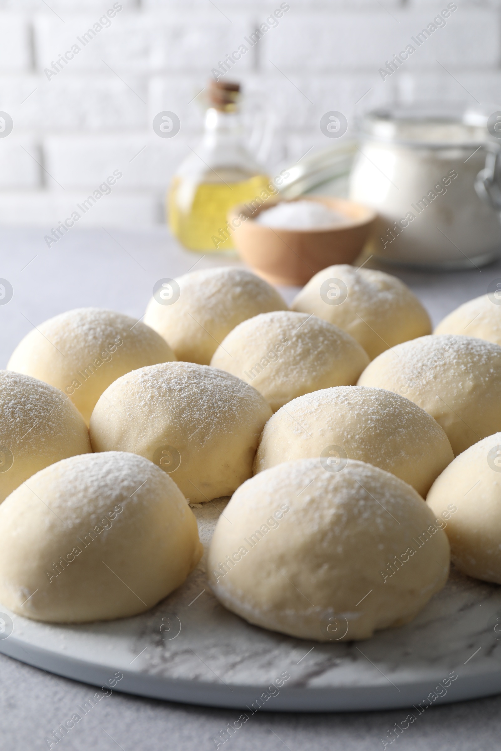 Photo of Raw dough balls on light grey table, closeup