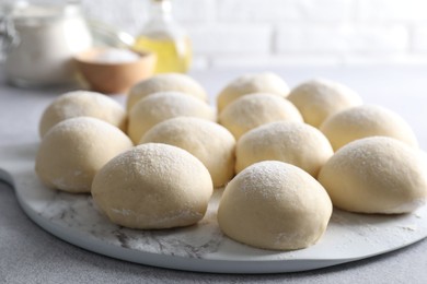 Raw dough balls on light grey table, closeup