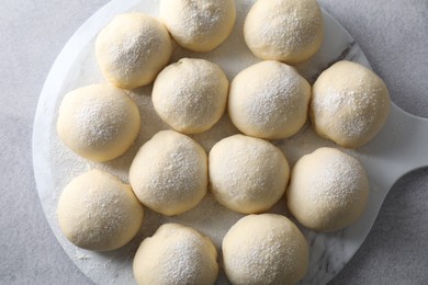 Photo of Raw dough balls on light grey table, top view