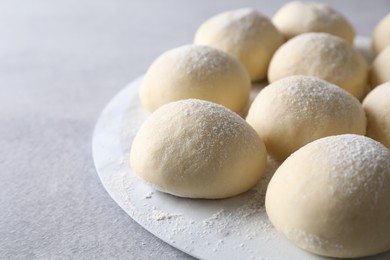 Raw dough balls on light grey table, closeup