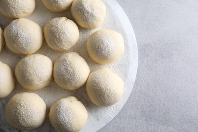 Raw dough balls on light grey table, top view. Space for text