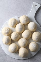 Raw dough balls on light grey table, top view