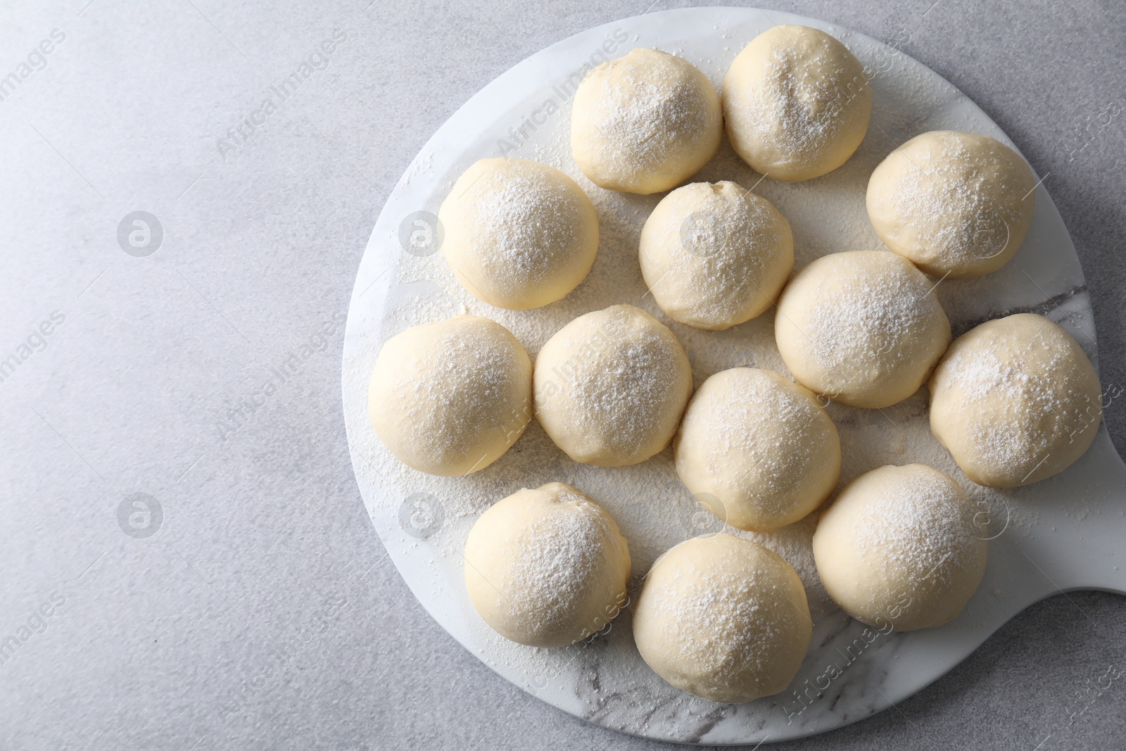 Photo of Raw dough balls on light grey table, top view. Space for text