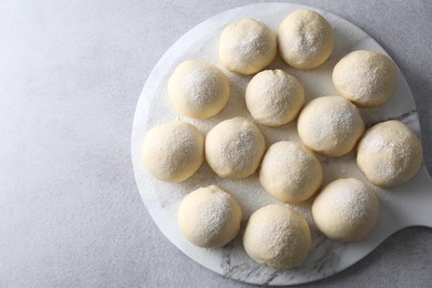 Raw dough balls on light grey table, top view. Space for text