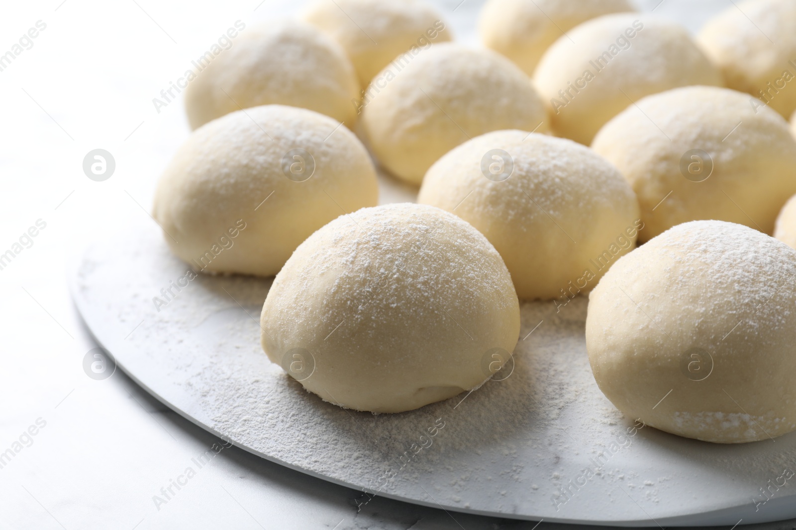 Photo of Many raw dough balls on white table