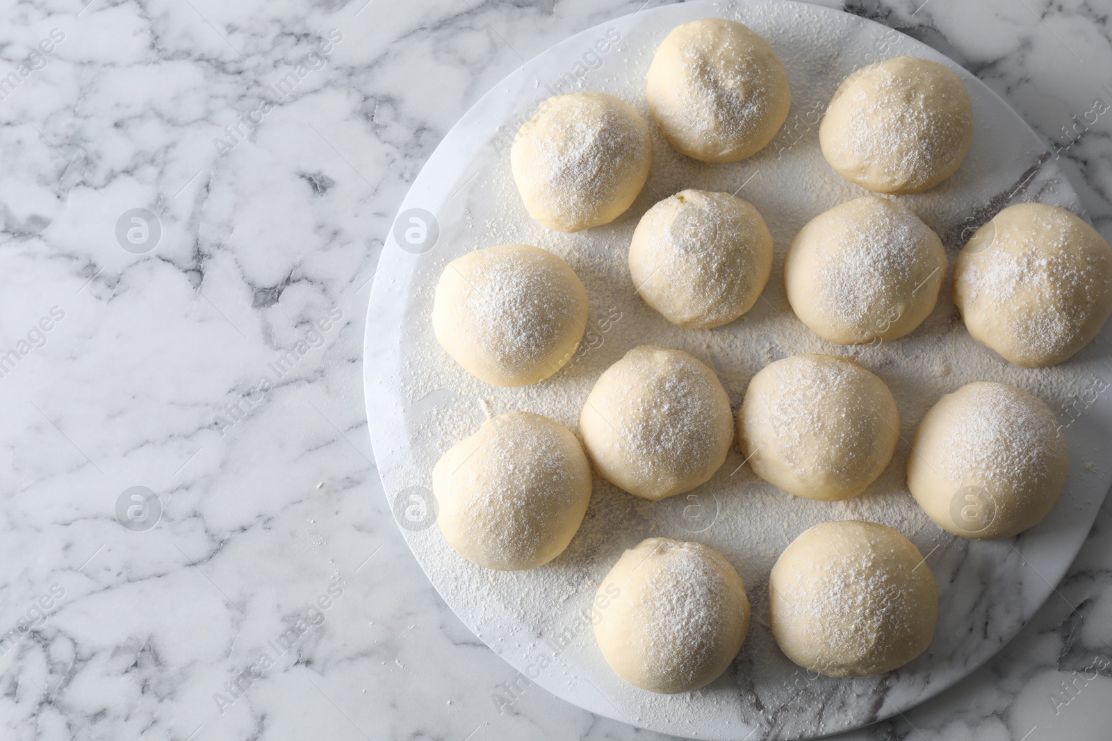 Photo of Raw dough balls on white marble table, top view. Space for text