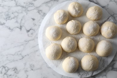 Raw dough balls on white marble table, top view. Space for text