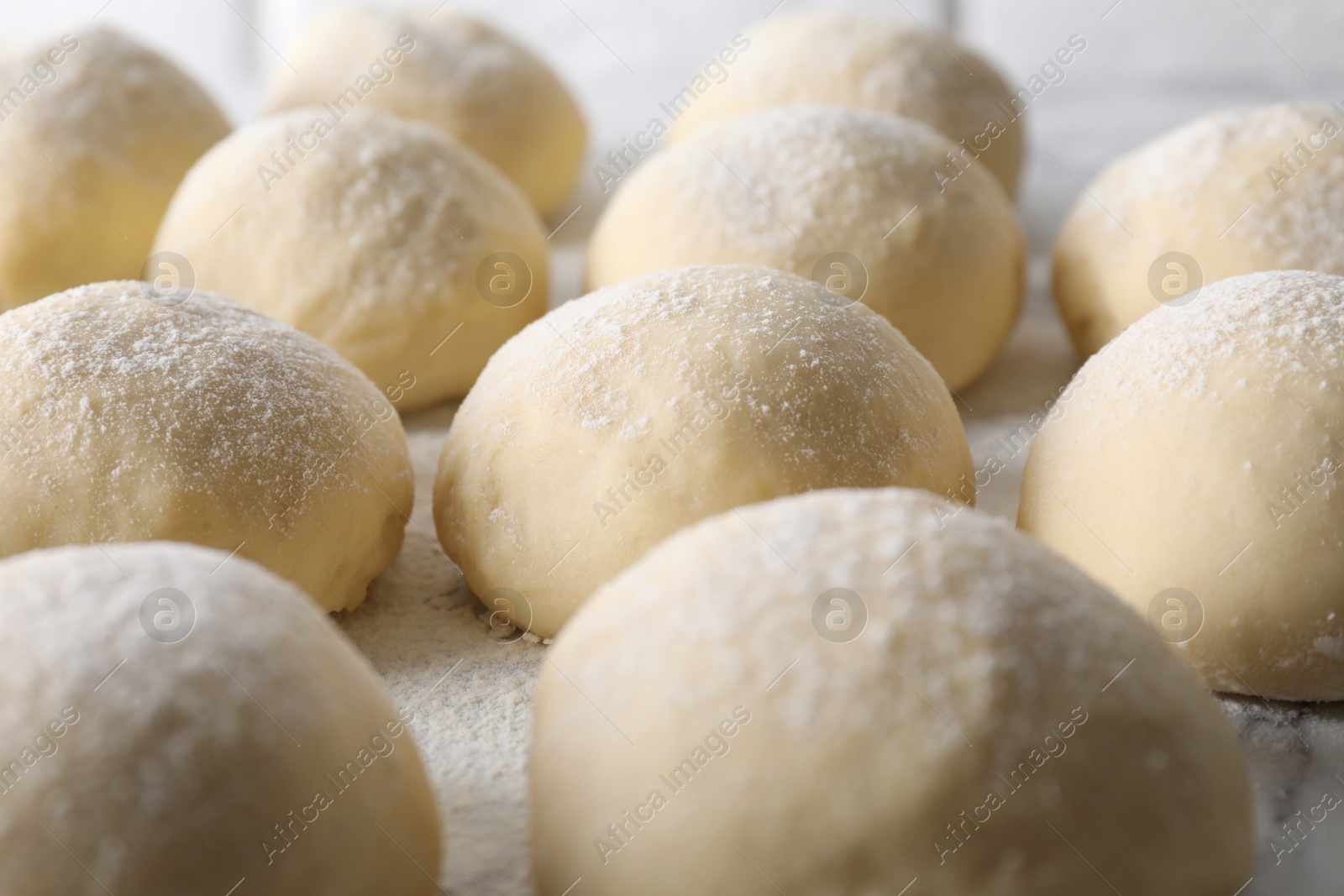 Photo of Many raw dough balls on board, closeup