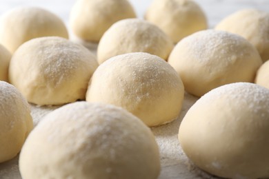 Photo of Many raw dough balls on board, closeup