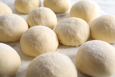 Photo of Many raw dough balls on board, closeup