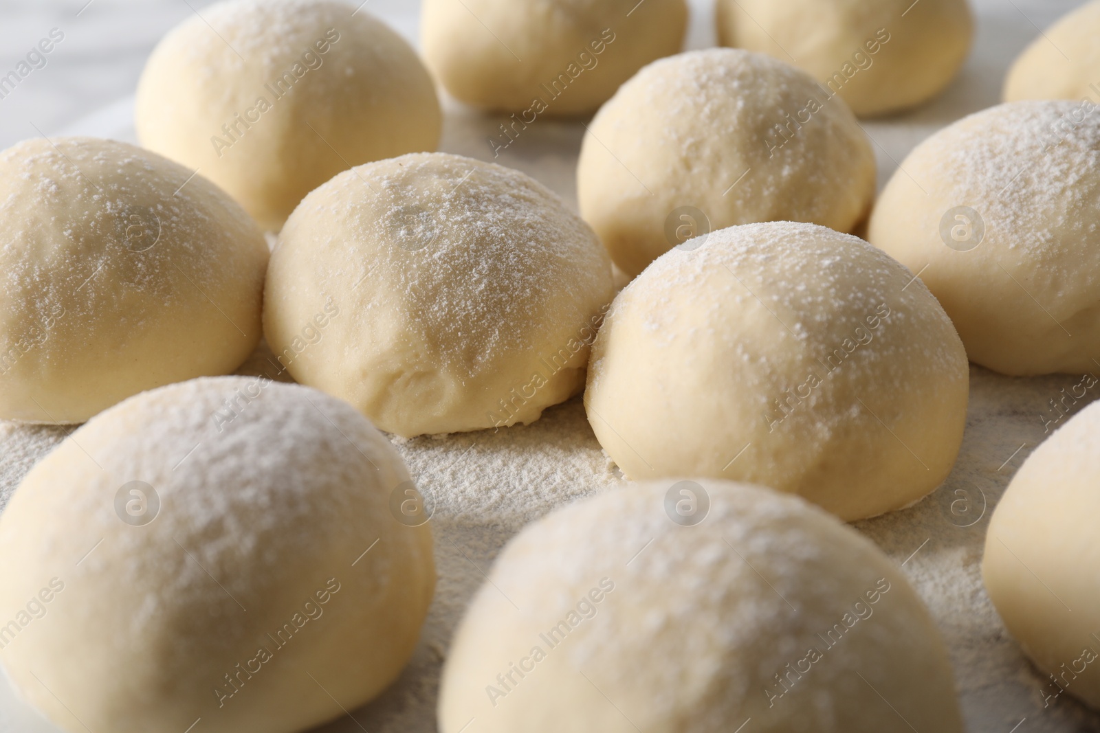 Photo of Many raw dough balls on board, closeup