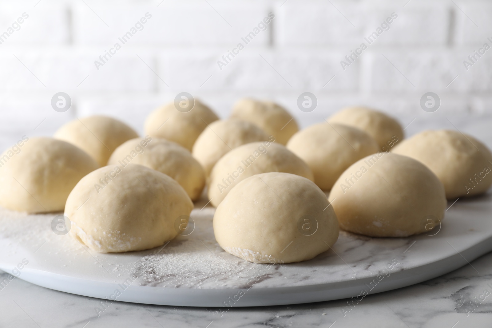 Photo of Raw dough balls on white marble table