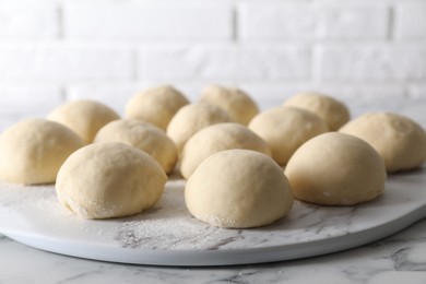 Raw dough balls on white marble table