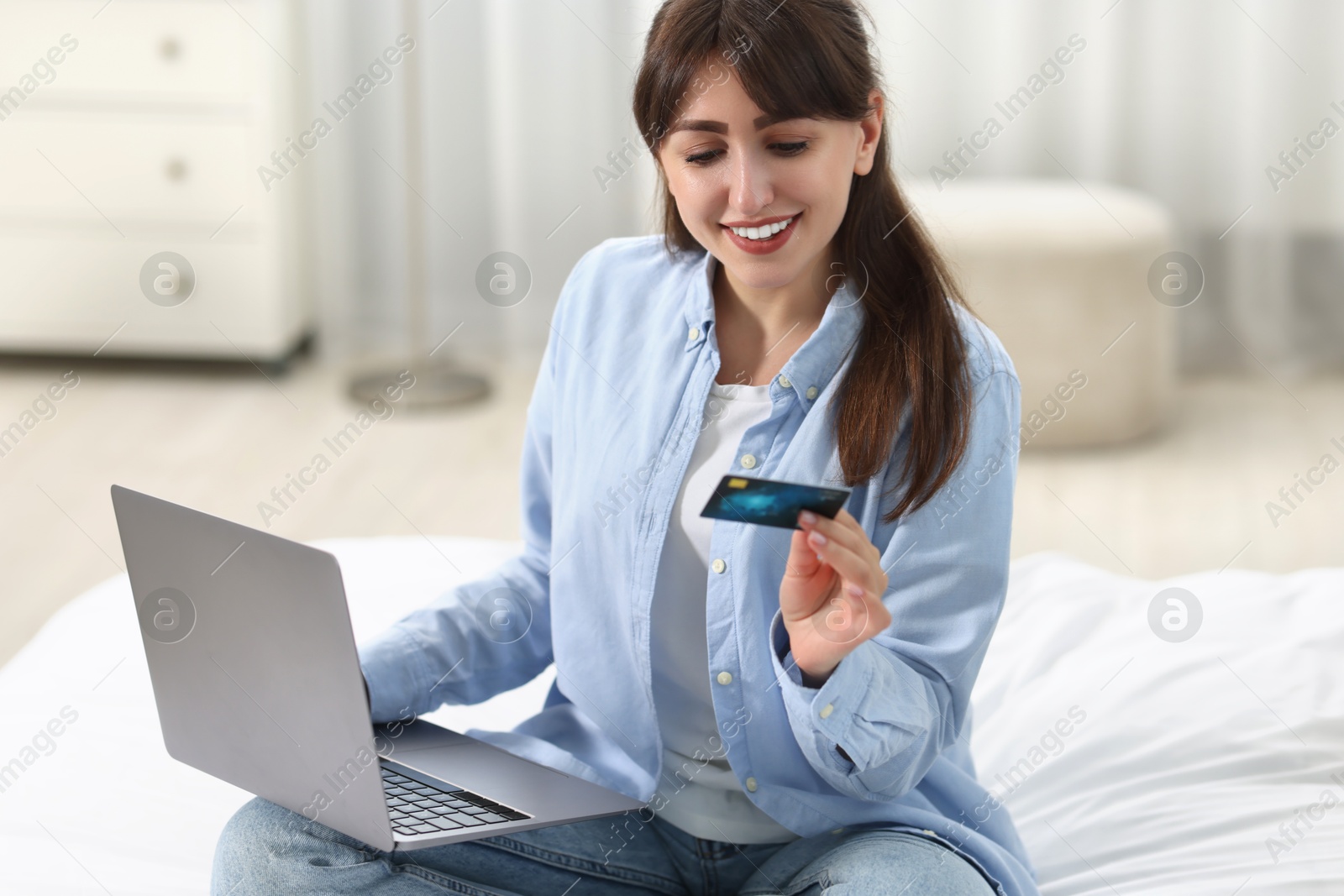 Photo of Online banking. Smiling woman with credit card and laptop paying purchase at home