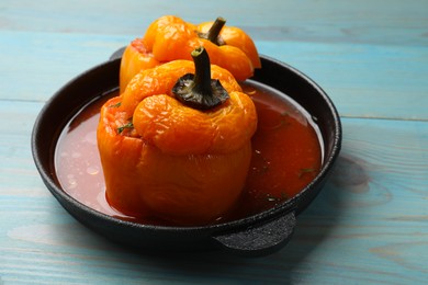 Photo of Tasty stuffed peppers on light blue wooden table, closeup